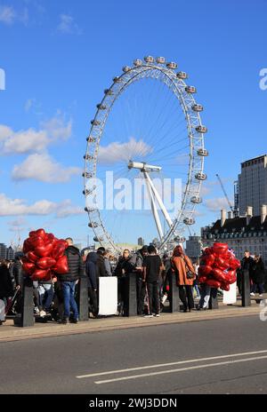 Rot, Valentine Heart Ballons werden auf der Westminster Bridge mit dem London Eye dahinter verkauft, Februar 2024, Großbritannien Stockfoto