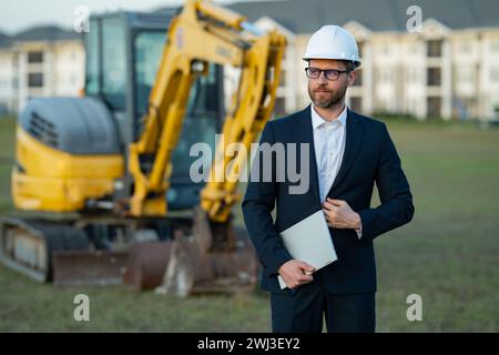 Buider-Mann in Anzug und Schutzhelm. Bauinvestor. Geschäftsmann-Investor vor der Baustelle. Erfolgreicher Investor. Ein hübscher Mann im Anzug Stockfoto