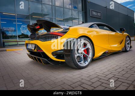 Der gelbe McLaren 765LT parkte an einem bewölkten Tag im Restyling Workshop. Stockfoto