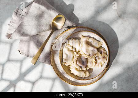 Teigtaschen mit Kirschen mit Sauerrahm und Zucker. Traditionelles Gericht der russischen, ukrainischen und belarussischen Küche, bekannt als Vareniki Stockfoto