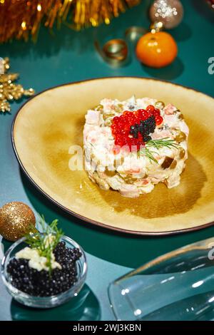 Nahaufnahme des Tellers mit portioniertem Olivier-Salat auf dem Silvestertisch. Party im russischen Stil Stockfoto