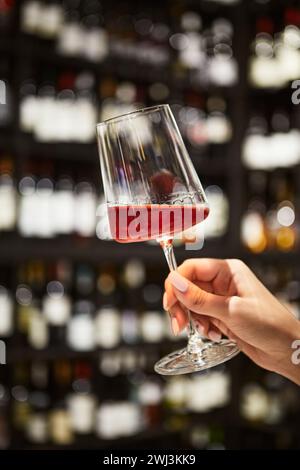 Frau Hand hält ein Glas Rotwein im Restaurant Stockfoto