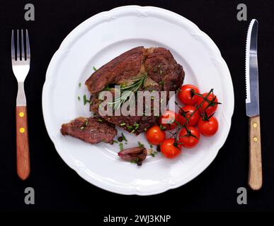 Rib Eye Steak mit Kirschtomaten, Knoblauch, Rosmarin Stockfoto