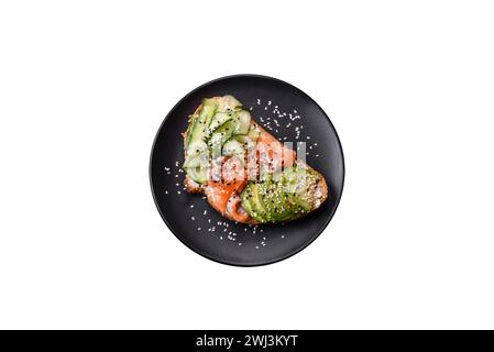 Frisches, leckeres Sandwich mit Lachs, Avocado, Sesam und Leinsamen Stockfoto