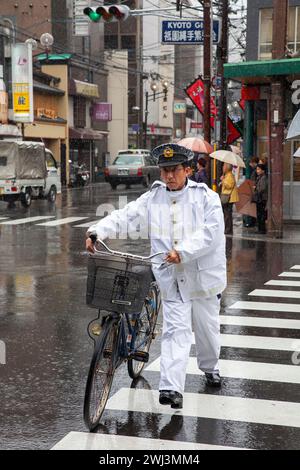 Szene mit Menschen und Verkehr auf der Shijo Street in der Innenstadt von Gion, Kyoto, Japan bei Regen. Stockfoto