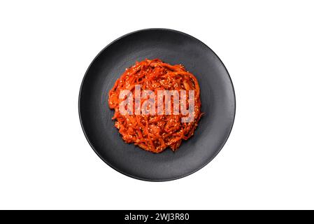 Getrockneter Tintenfisch, in Scheiben geschnitten und mit Sesamsamen und Gewürzen abgeschmeckt Stockfoto