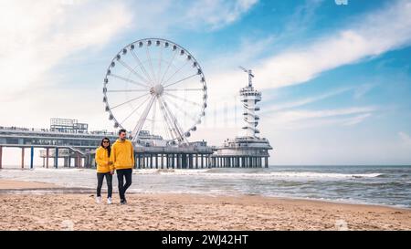 Paare am Strand von Schevening Niederlande im Frühling, Riesenrad der Pier in Scheveningen Stockfoto