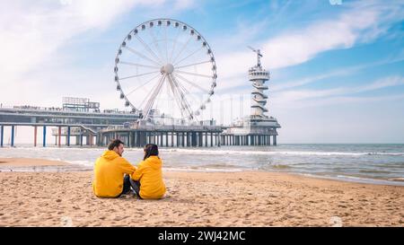 Paare am Strand von Scheveningen Niederlande im Frühling, Riesenrad der Pier in Scheveningen Stockfoto