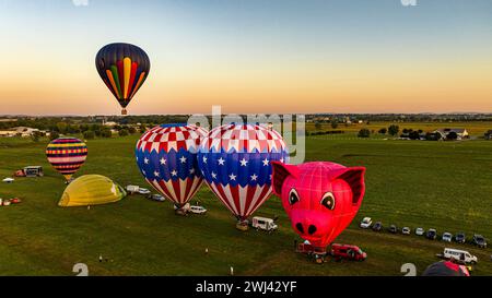 Luftaufnahme auf zwei Heißluftballons, die am frühen Morgen von einem Feld im ländlichen Amerika starten Stockfoto