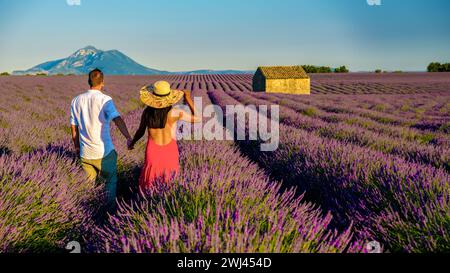 Ein Paar, das in einem Lavendelfeld in Frankreich in der Valensole Provence spaziert Stockfoto