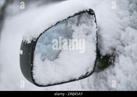 Schneebedeckter Seitenspiegel eines Autos, gefährliches Fahren im Winter, Kopierraum, ausgewählter Fokus Stockfoto