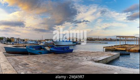 Fischerboote und Docks im Handelshafen von Taranto bei Sonnenuntergang Stockfoto