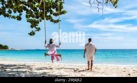 Ein paar Männer und Frauen an einer Schaukel am Strand von Koh Samet I Stockfoto