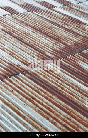 Abstrakt des alten Metallblechdachs, rostiges galvanisiertes Wellpappe weit verbreitet für seine Haltbarkeit und sein unverwechselbares Aussehen, weicher Fokus Stockfoto