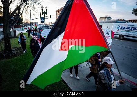 Bakersfield, Kalifornien, USA. Februar 2024. Eine Frau trägt die palästinensische Flagge am 12. Februar 2024 in Bakersfield, Kalifornien, während einer Notfalldemonstration, die darauf aufmerksam machen sollte, dass die IDF während des Super Bowl LVIII Rafah gezielt bombardiert hat. Die Stadt Rafah ist zum letzten Zufluchtsort für das palästinensische Volk geworden, das in Gaza belagert wird. (Credit Image: © Jake Lee Green/ZUMA Press Wire) NUR REDAKTIONELLE VERWENDUNG! Nicht für kommerzielle ZWECKE! Stockfoto