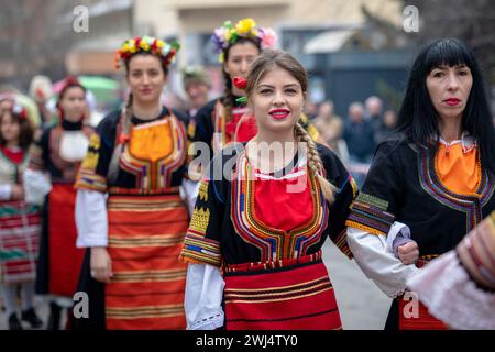 Kyustendil, Bulgarien - 10. Februar 2024: Erste Ausgabe eines Maskerade-Festivals in Kyustendil Bulgarien. Frauen in Nationalkostümen tanzen und Stockfoto