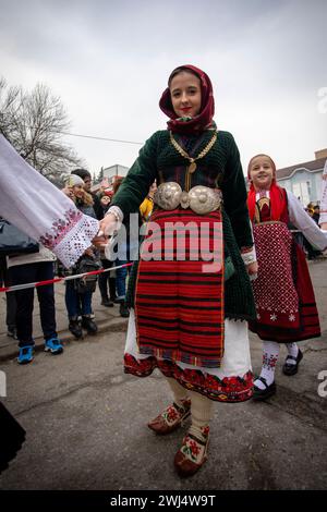 Kyustendil, Bulgarien - 10. Februar 2024: Erste Ausgabe eines Maskerade-Festivals in Kyustendil Bulgarien. Frauen in Nationalkostümen tanzen und Stockfoto
