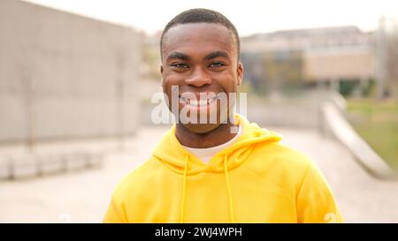 Ein afrikanischer junger Mann, der steht und lächelt Stockfoto
