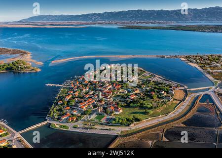 Nin, Kroatien - Panoramablick aus der Vogelperspektive auf die historische Stadt und die kleine Insel Nin mit traditionellen Salz-Stillfeldern und dem blauen Adriatischen Meer bei Sonne Stockfoto