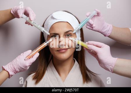 Konzeptuelle Schönheit und kosmetologische Darstellung der Hände mehrerer Kosmetikerinnen, die ihre jeweiligen Geräte halten. Schönheitskonzept. Stockfoto