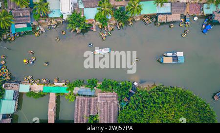 Aus der Vogelperspektive entspannen sich die Touristen und erleben eine Korbboottour im Kokosnusswasser (Mangrovenpalmen) Wald im Dorf Cam Thanh, Hoi an, Quang Na Stockfoto