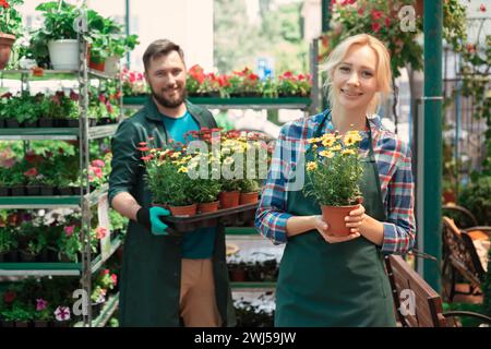 Gärtner, die im Gartencenter mit Blumen arbeiten Stockfoto