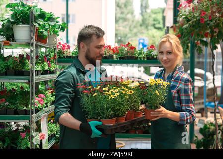 Gärtner, die im Gartencenter mit Blumen arbeiten Stockfoto