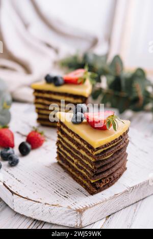 Köstlicher, frischer Schokoladenkuchen mit Beeren auf Holztisch Stockfoto