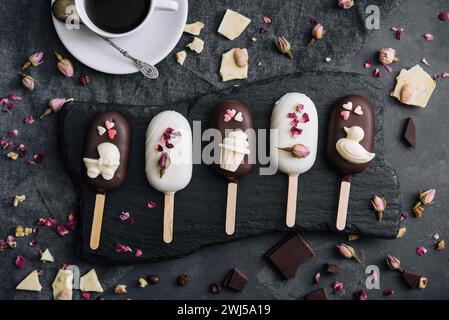 Blick von oben auf dekorierte Kuchen Pops Eis auf schwarzem Hintergrund Stockfoto