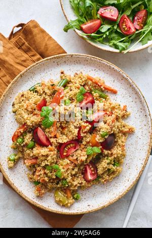 Veganer warmer Salat mit Couscous, Tomaten, grünen Bohnen, Minze, gerösteten Karotten und süßen Paprika. Couscous mit Gemüse drin Stockfoto