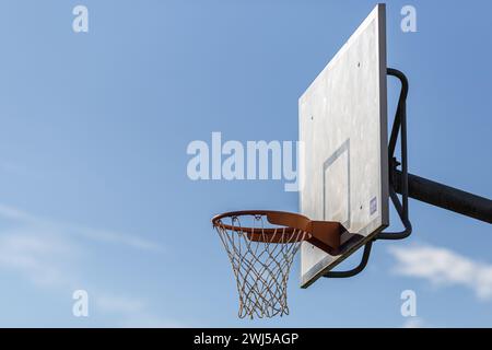 Ein Basketballkorb und Backboard im Freien mit blauem Himmel und Netz Stockfoto