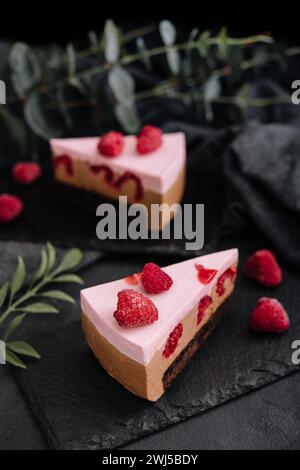 Käsekuchen mit Himbeeren auf schwarzem Brett Stockfoto