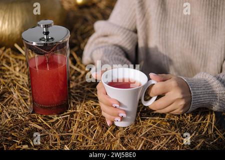 Eine Frau hält eine Tasse Tee nahe Stockfoto