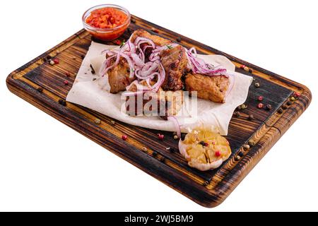 Barbecue mit Sauce und eingelegten Zwiebeln auf einem Holzbrett Stockfoto