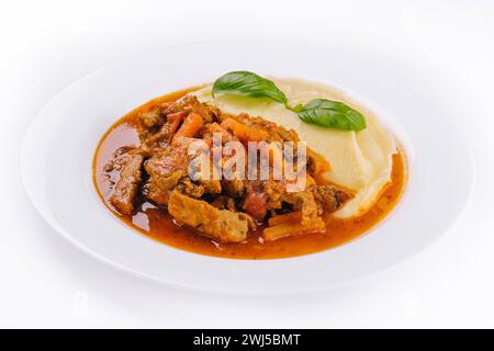 Mittagessen mit Rindfleisch-Bourguignon-Eintopf, serviert mit Kartoffelpüree auf einem Teller Stockfoto