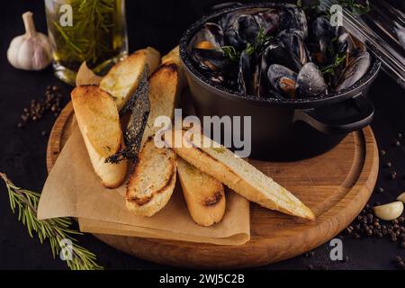 Traditionelles Barbecue italienische Blaumuschel in Weinsauce mit Baguettebrot Stockfoto