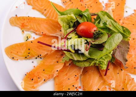 Scheiben von rohem Lachsfilet auf weißer Platte Stockfoto