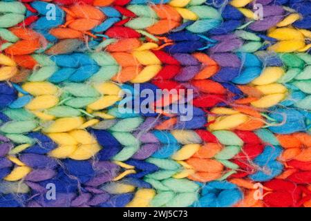 Nahaufnahme eines gestrickten, farbenfrohen Wollschals, Hintergrundstruktur aus mehrfarbiger geflochtener Wolle Stockfoto