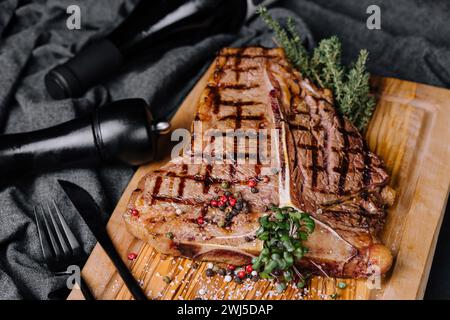 Ein großes gegrilltes Steak auf einem Holzteller Stockfoto