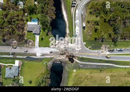 Baumaschinen auf Baustellengelände. Wiederaufbau einer beschädigten Straßenbrücke, die durch den Fluss zerstört wurde, nachdem das Wasser Asphalt weggespült hatte. Neuaufbau Stockfoto