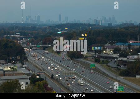 American Freeway mit schnell fahrenden Autos und Lastwagen und Hochhäusern von Atlanta City im Bundesstaat Georgia. Blick von oben auf den Transport der USA Stockfoto