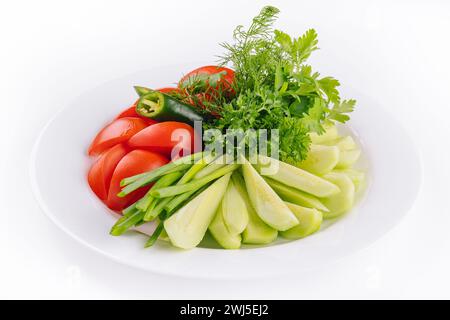 Veganer Teller mit frischen Gurken, grünen Zwiebeln und Kirschtomaten Stockfoto