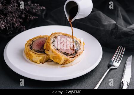 Filet wellington in Blätterteig auf Teller Stockfoto