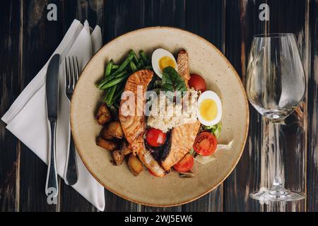 Köstlicher Lachs aus Meeresfrüchten. Serviert mit grünen Bohnen und einem Couscous, Tomaten, Ei und Kartoffeln Stockfoto