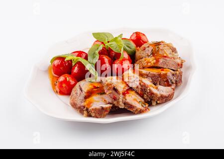 Gebackener Hackbraten mit Spinat und Tomaten, isoliert auf weiß Stockfoto