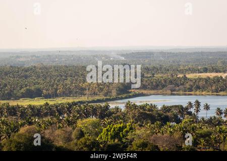 Dieses Bild bietet einen atemberaubenden Panoramablick auf die ruhige Stadt Shravanabelagola, eingebettet in üppiges Grün und einen ruhigen See unter dem g Stockfoto