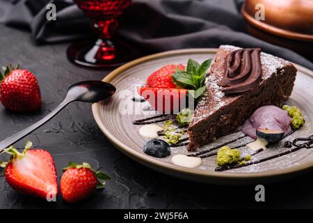 Brownie-Kuchen mit einer Schaufel Vanilleeis und Erdbeeren Stockfoto