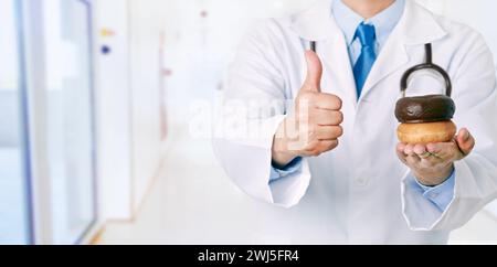 Vorderansicht Nahaufnahme eines männlichen Arztes Hand, der Donuts im Krankenhaus hält Stockfoto