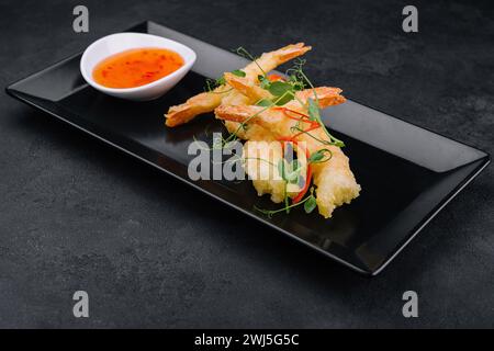 Gebratene Garnelen Tempura mit süßer Chili-Sauce auf schwarzem Steinteller Stockfoto