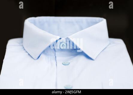 Nahaufnahme eines blauen Herrenhemdes mit schwarzem Hintergrund Stockfoto